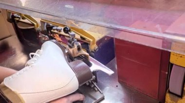 Buz pateni makinede keskinleştiriliyor, kıvılcımlar uçuşuyor, üst görüntü, yakın çekim.