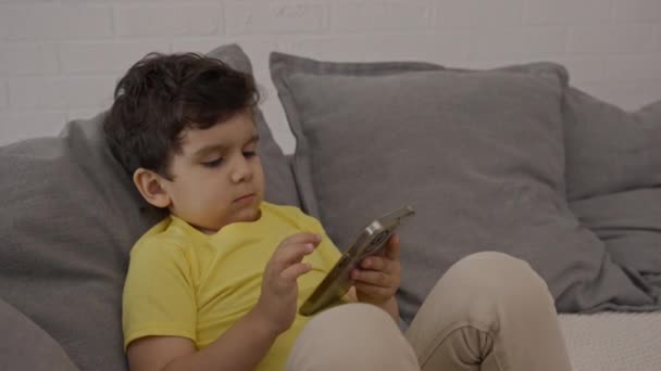Petit Enfant Doux Détendre Sur Canapé Utilisant Une Application Électronique — Video