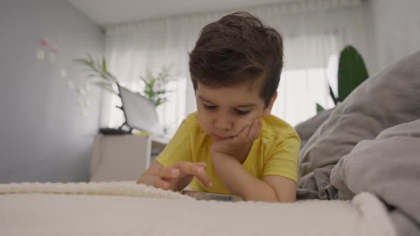 Søte Lille Barn Som Ligger Sofa Tar Mobiltelefon Mens Spiller – stockvideo