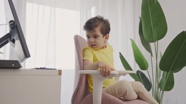 Kleine Jongen Ontspannen Comfortabele Modieuze Roterende Stoel Voorkant Van Laptop — Stockvideo
