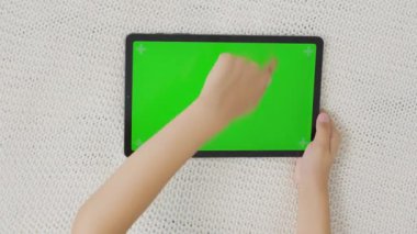 El ele tutuşup yatay yeşil ekranlı bir tablet bilgisayara tıklıyoruz. Model. 