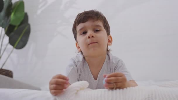 リラックスした小さな男の子の近くに白い新鮮な寝具で両親のベッドでフリック 幸福と幸せな子供時代の概念 — ストック動画