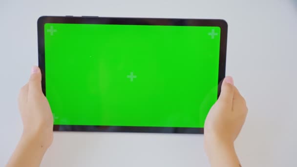 横の緑色のスクリーンでタブレットコンピュータを保持してタップする手の子供を閉じます モックアップ — ストック動画