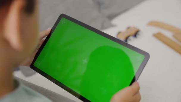 緑色のスクリーン 側面のビューが付いているタブレットPcを左右に傾ける子供 — ストック動画