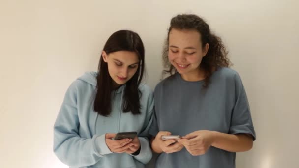 Ellerinde Telefon Olan Kızlar Modeller Gülümser Telefonlarında Notlar Gösterirler — Stok video