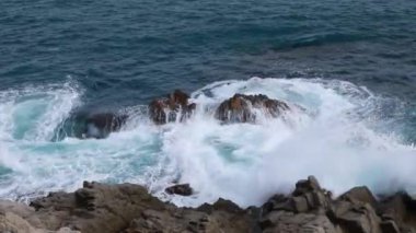 Dalgaları denizdeki kayalıklarda kırın. Su elementi.