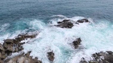 Deniz manzarası, dalgalar denizdeki kayalarda kırılıyor. Mavi deniz sörfünün üst manzarası, fırtına