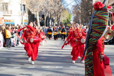 Davullu kırmızı elbiseli sanatçılar. Çinliler İspanya 'da Çin Yeni Yılı' nı kutluyorlar, Barselona 01.25.2025