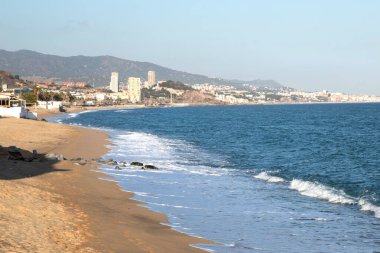 Deniz, şehir ve dağ manzaralı kentsel kumsal