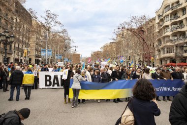 Ukraynalılarla birlikte Avrupalılar ve diğer uluslar Ukrayna 'nın mitingine ulusal sembollerle destek verdiler. Rusya 'nın Ukrayna' yla üç yıllık savaşı. İspanya Barselona 23.02.2035