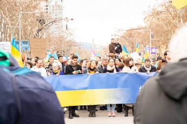 Ukraynalılarla birlikte Avrupalılar ve diğer uluslar Ukrayna 'nın mitingine ulusal sembollerle destek verdiler. Rusya 'nın Ukrayna' yla üç yıllık savaşı. İspanya Barselona 23.02.2035