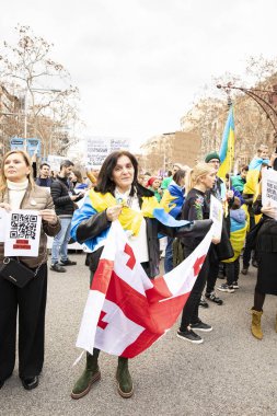 Ukraynalılarla birlikte Avrupalılar ve diğer uluslar Ukrayna 'nın mitingine ulusal sembollerle destek verdiler. Rusya 'nın Ukrayna' yla üç yıllık savaşı. İspanya Barselona 23.02.2035