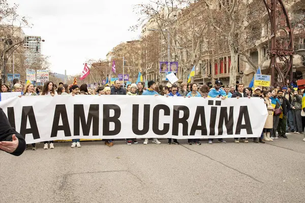 Ukraynalılarla birlikte Avrupalılar ve diğer uluslar Ukrayna 'nın mitingine ulusal sembollerle destek verdiler. Rusya 'nın Ukrayna' yla üç yıllık savaşı. İspanya Barselona 23.02.2035
