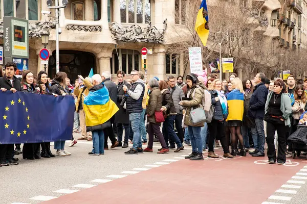 Ukraynalılarla birlikte Avrupalılar ve diğer uluslar Ukrayna 'nın mitingine ulusal sembollerle destek verdiler. Rusya 'nın Ukrayna' yla üç yıllık savaşı. İspanya Barselona 23.02.2035