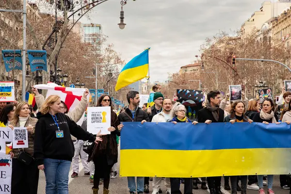 Ukraynalılarla birlikte Avrupalılar ve diğer uluslar Ukrayna 'nın mitingine ulusal sembollerle destek verdiler. Rusya 'nın Ukrayna' yla üç yıllık savaşı. İspanya Barselona 23.02.2025