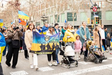 Ukrayna 'da 3 yıl süren savaşın onuruna Katalonya sokaklarında posterleri ve bayrakları olan Ukrayna gösterileri. Ukraynalıların Barselona 'daki mitingi 23.02.2025