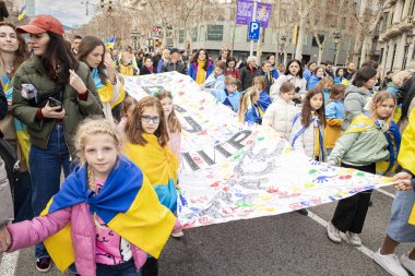 Ukrayna gösterisindeki çocuklar, Ukrayna 'da 3 yıl süren savaşın onuruna Katalonya sokaklarında posterler ve bayraklarla gösteri yaptılar. Ukraynalıların Barselona 'daki mitingi 23.02.2025