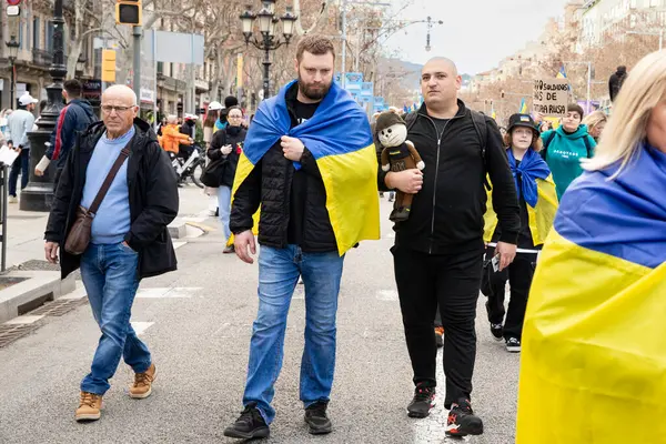 Ukrayna 'da 3 yıl süren savaşın onuruna Katalonya sokaklarında posterleri ve bayrakları olan Ukrayna gösterileri. Ukraynalıların Barselona 'daki mitingi 23.02.2025