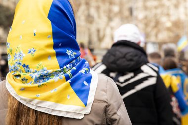 Ukr bayrağı renginde başörtüsü. Ukraynalılarla birlikte Avrupalılar, Ukrayna 'nın ulusal sembollü mitingine destek veriyorlar. Rusya ve Ukrayna arasındaki üç yıllık savaş. İspanya Barselona 02.23.2025