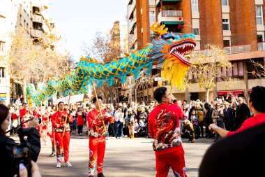 Bir ejderhayla geleneksel kostümlü Çin geçidi. İnsanlar İspanya 'da Çin Yeni Yılı' nı kutluyor, Barselona 25.01.2025