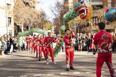 Bir ejderhayla geleneksel kostümlü Çin geçidi. İnsanlar İspanya 'da Çin Yeni Yılı' nı kutluyor, Barselona 25.01.2025