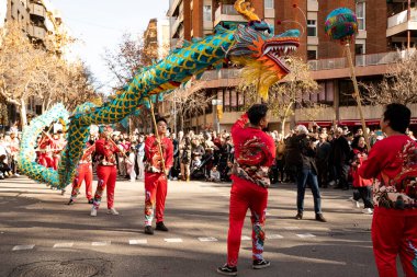 Bir ejderhayla geleneksel kostümlü Çin geçidi. İnsanlar İspanya 'da Çin Yeni Yılı' nı kutluyor, Barselona 25.01.2025