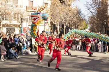 Bir ejderhayla geleneksel kostümlü Çin geçidi. İnsanlar İspanya 'da Çin Yeni Yılı' nı kutluyor, Barselona 25.01.2025