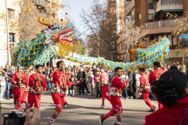 Bir ejderhayla geleneksel kostümlü Çin geçidi. İnsanlar İspanya 'da Çin Yeni Yılı' nı kutluyor, Barselona 25.01.2025