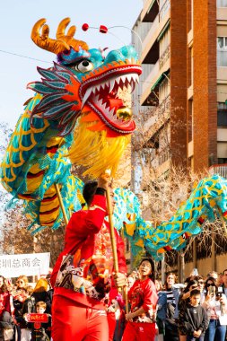 Bir ejderhayla geleneksel kostümlü Çin geçidi. İnsanlar İspanya 'da Çin Yeni Yılı' nı kutluyor, Barselona 25.01.2025