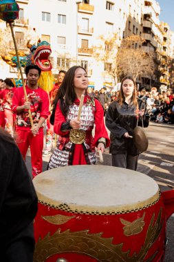 Bir ejderhayla geleneksel kostümlü Çin geçidi. İnsanlar İspanya 'da Çin Yeni Yılı' nı kutluyor, Barselona 25.01.2025
