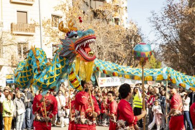 Bir ejderhayla geleneksel kostümlü Çin geçidi. İnsanlar İspanya 'da Çin Yeni Yılı' nı kutluyor, Barselona 25.01.2025