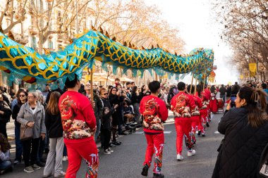 Bir ejderhayla geleneksel kostümlü Çin geçidi. İnsanlar İspanya 'da Çin Yeni Yılı' nı kutluyor, Barselona 25.01.2025