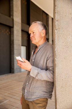 Teknolojiden anlayan yaşlı bir adam. Telefonu olan adam.