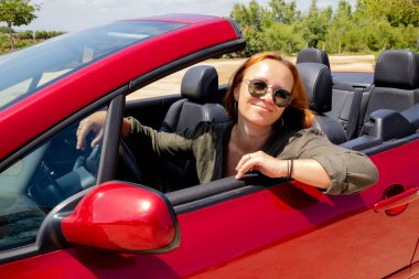 Cabriolet 'te gezinin tadını çıkaran şık şoför kadın.