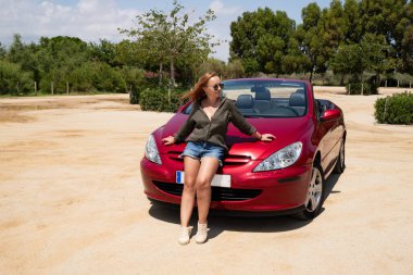 Yazın kırmızı Cabriolet ile poz veren şık bir kadın.