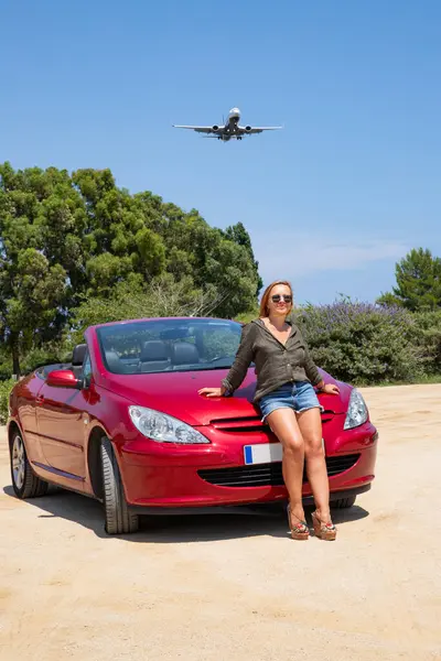 Üstü açık arabayla gökyüzüne karşı uçan bir kız, yaz tatili.