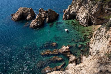 İspanya 'nın Tossa de Mar şehrinde güzel bir sahil ve denizde bir tekne.