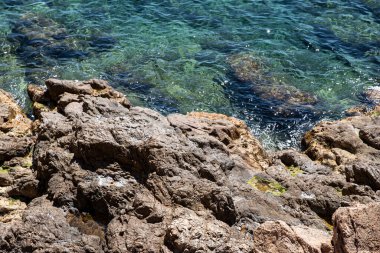 Tossa de Mar 'daki kayalık kıyı ve mavi berrak su, deniz manzarası