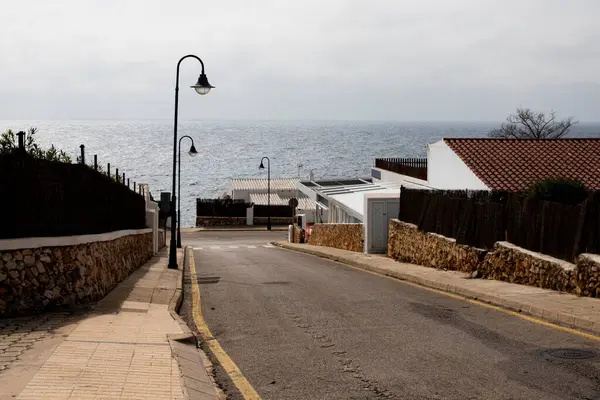 Denize giden boş bir yol. Beyaz evleri olan deniz kenarı kasabası