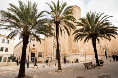 Mağazaları ve heykeli olan büyüleyici şehir caddesi, İspanya 'nın Menorca kentinin ruhunu yansıtıyor. Pazar meydanı ve tapınağı 08.03.2025