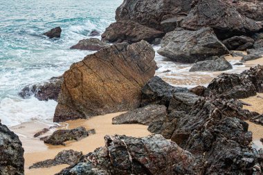 Doğanın güzelliği, deniz manzarası. Büyük taşları ve deniz köpüğü olan sahil.