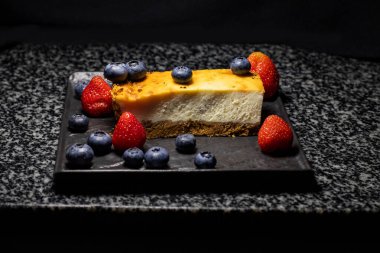 Böğürtlenli tatlı, siyah arkaplanda cheesecake ve metin için boşluk