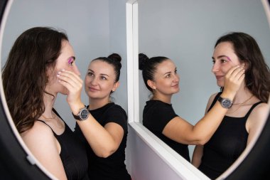 Maskeli müşterilerin kaşlarını şekillendiren güzellik uzmanı. Güzellik salonu