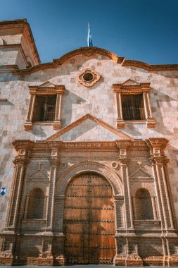 Arequipa Peru 'daki Iglesia de San Francisco' da yemyeşil ve canlı kültürlerle çevrili çarpıcı bir koloni mimarisi sergilenmektedir.