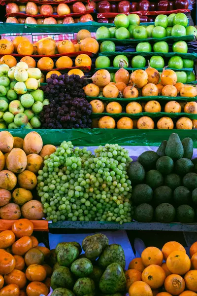 Canlı bir Peru meyve pazarı taze portakal, avokado, elma ve Cherimoya rengarenk ürünleri sergiliyor.