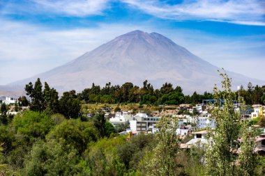 Misti Volkanı 'nın berrak gökyüzü ve dağlık manzarasıyla Arequipa şehrinin üzerinde yükselen çarpıcı manzarası.