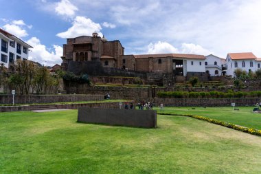 Cusco Peru 'daki Coricancha Tapınağı' nda parlak mavi gökyüzü altında İnka duvarları ve sömürge mimarisi yer alıyor.