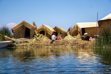 Peru 'daki Titicaca Gölü' nde yüzen Uros Adalarının Renkli Reed Evleri ve Suyun Güzel Yansımaları Manzarası
