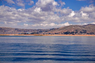 Peru 'daki Titicaca Gölü' nden Puno şehrinin nefes kesici manzarası ve açık mavi gökyüzü.