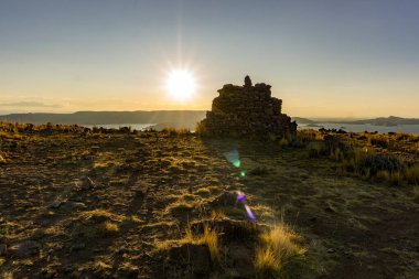 Peru, Titicaca Gölü 'ndeki Amantani Adası' ndaki Pachamama tapınağındaki antik İnka öncesi kalıntıların günbatımı manzarası